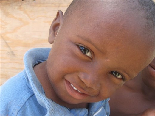 A Haitian child figuring out what a camera device is for.