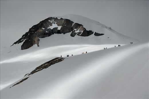 Scientists and adventurers scale this mountain at Necko Harbour. A break in the clouds imparts slithers of transient silver light, a constant reminder that mankind will always be at the mercy of the natural world.
