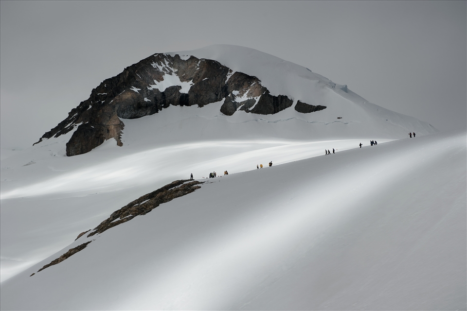 Scientists and adventurers scale this mountain at Necko Harbour. A break in the clouds imparts slithers of transient silver light, a constant reminder that mankind will always be at the mercy of the natural world.