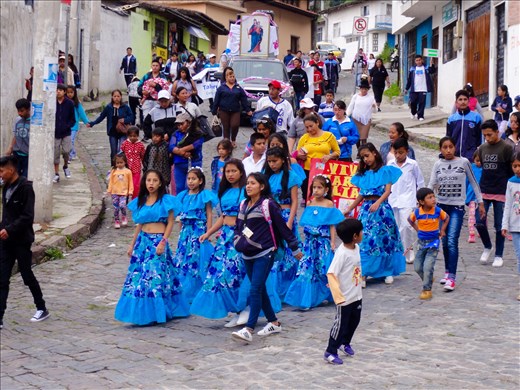 Parade in Quito heading down to old historic church  in a deep valley.