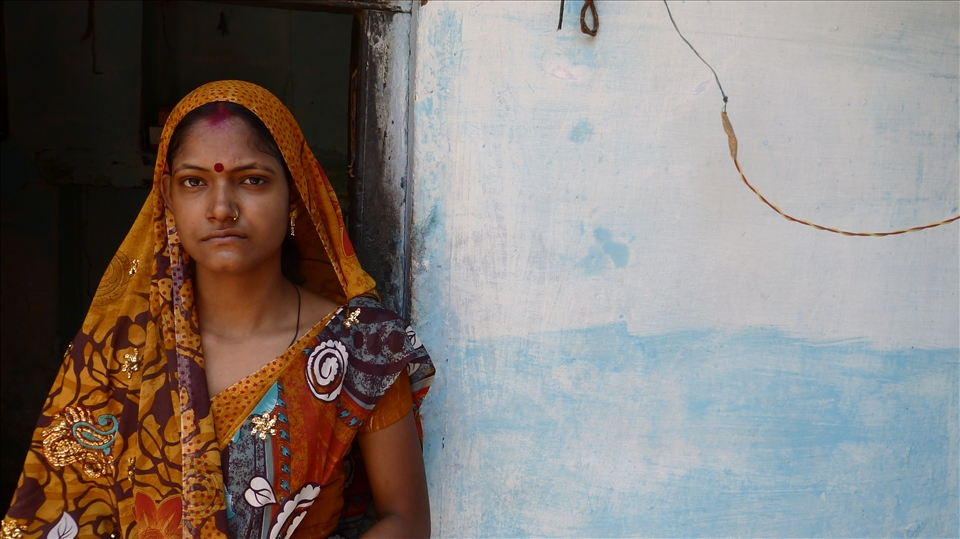 Portrait of a women outside her one-bedroom home in Varanasi