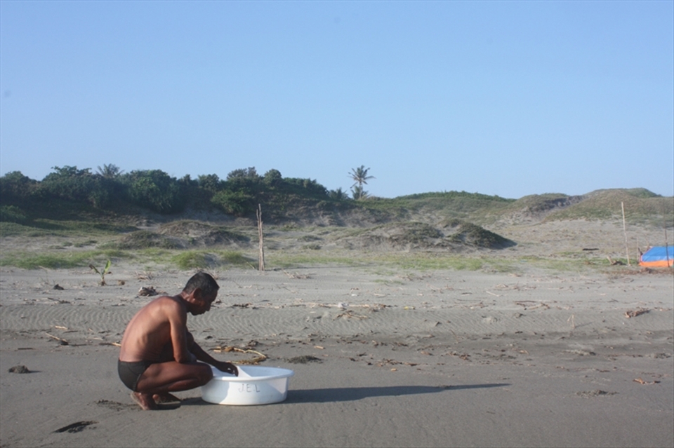 Fisherman checking for small fish he grow and eventually sell. He wasn't lucky that day, he tells me. But was quick to add, that tomorrow is another day.