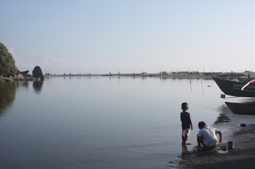 Children of fishermen wading at shallow waters, looking for things that washed up on their shore, looking ahead for their fathers out at sea; looking at the future.