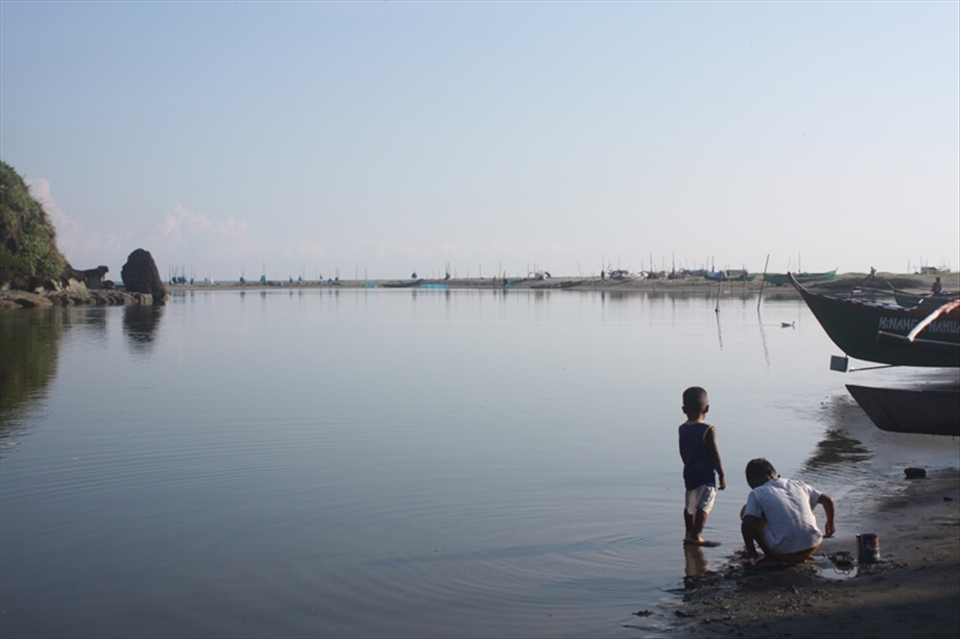 Children of fishermen wading at shallow waters, looking for things that washed up on their shore, looking ahead for their fathers out at sea; looking at the future.
