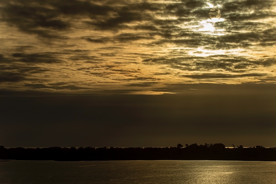 Sunset in Budi Lake (the only Salt water lake in South America), lake that was born after the Tsunami on May 22th,1960. The picture also 
shows a bit of the Pacific Ocean above the hill and the sun hidden behind the clouds.