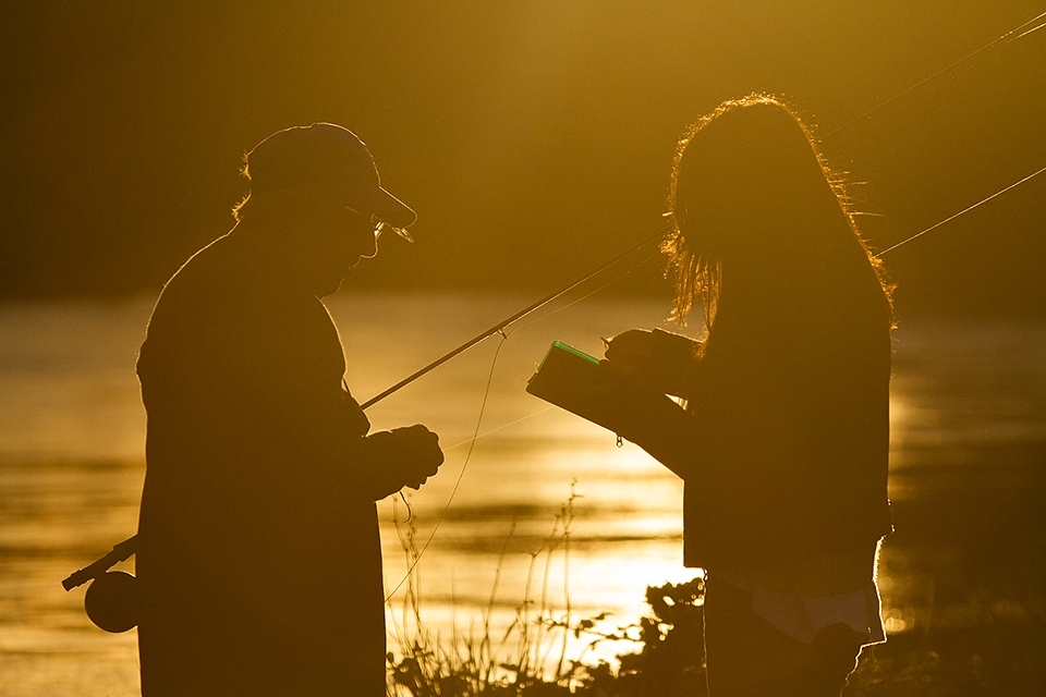 Fly fishing in the Patagonia is one of the most important activities in summer in Argentina and Chile. Here is a guy being advised for her grandaughter, who is giving him the right fly. Later that sunset the grandfather has caught a beautiful rainbow trout with the fly that his grandaughter gave him before, it was a magical moment, the face of the girl was full of tears, tears of happiness after she saw his grandfather landing that beautiful trout.