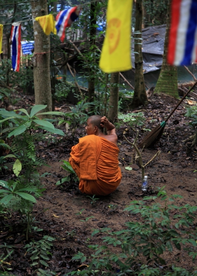 A Lone monk sits on a small piece of real estate high on a hill on koh samui. while next door a 100 room tourist resort caters for the guests every need in excess luxury.