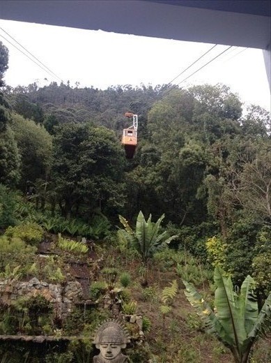 Un teleférico rides its cable down from the summit 