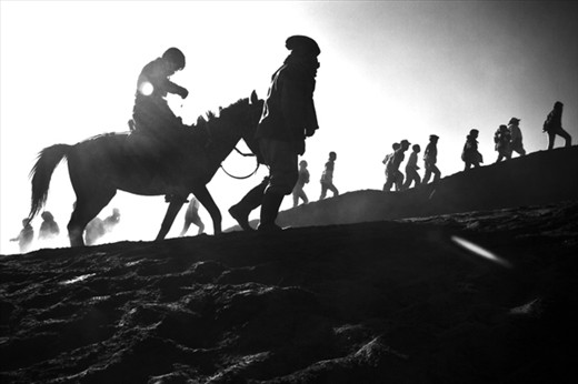 Tenggerese along with the tourists climb to the crater of Mt. Bromo where the offering by the Hindunese is being thrown as part of the Kasada Ceremony. East Java, Indonesia.