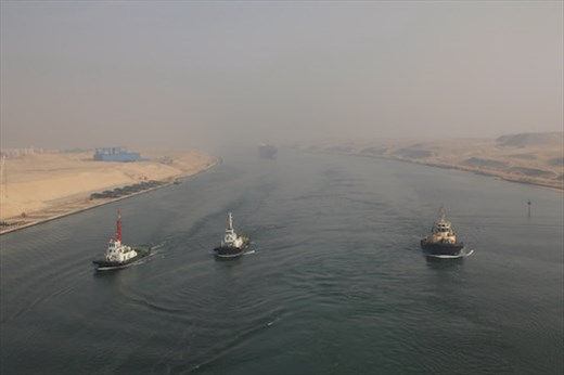 Looking astern, 3 tugs and a container ship