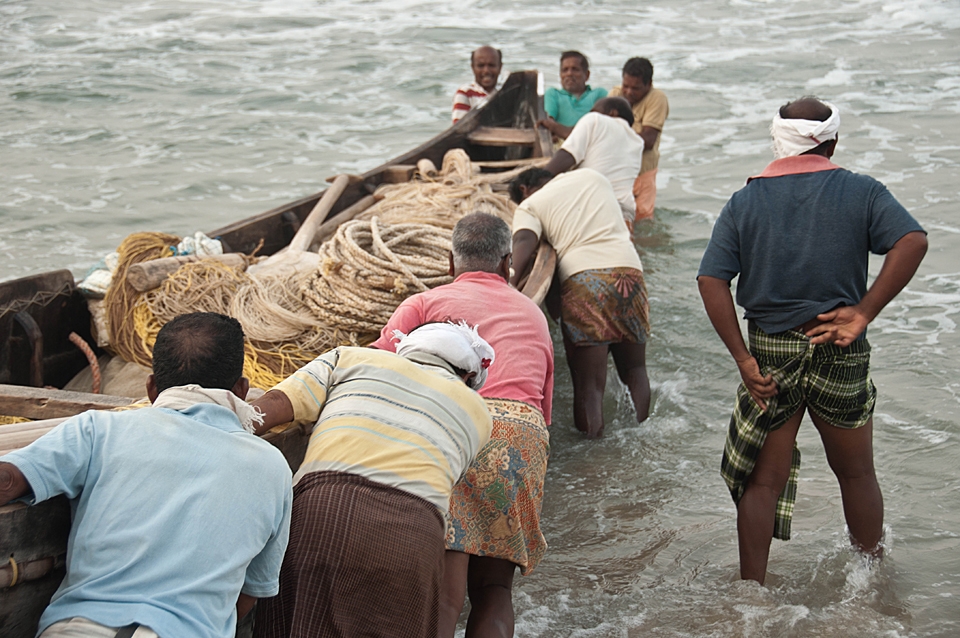 As we getting close to the water begins the most critical step. The weaves are strong and the fishermen cannot stop pushing. They are encouraging themselves all together. When the boat is on a trip they just have to install the long fishing net. 