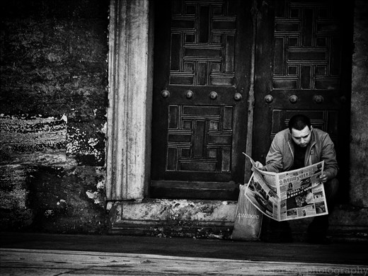 A man casually reads the newspaper at The Blue Mosque