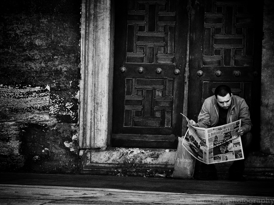 A man casually reads the newspaper at The Blue Mosque