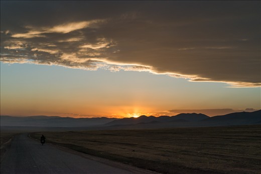 Bikers riding in the sunset after the storm.