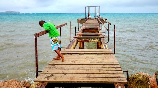 Broken Dreams - A Papuan boy stares down a broke pier in Port Moresby.