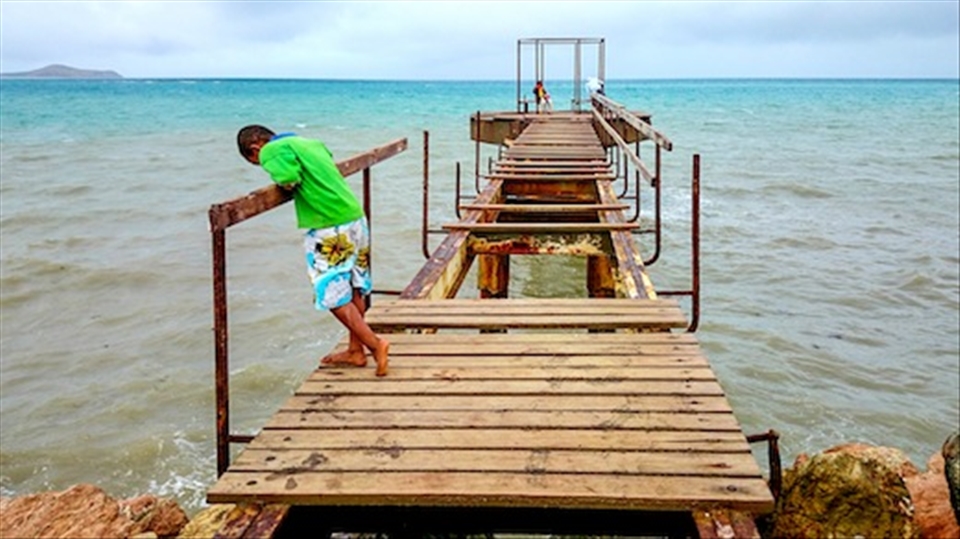 Broken Dreams - A Papuan boy stares down a broke pier in Port Moresby.