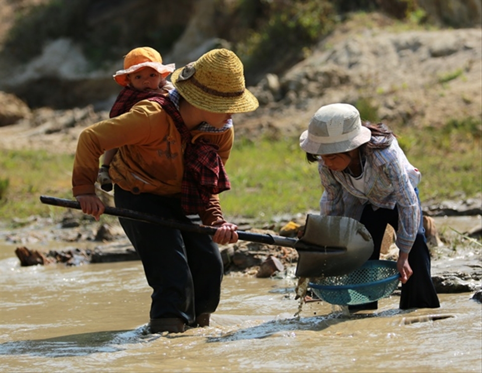 The whole Co Ho family has to work hard to ensure the daily livelihood. Here  they are panning tin from a stream drift in the mountains.