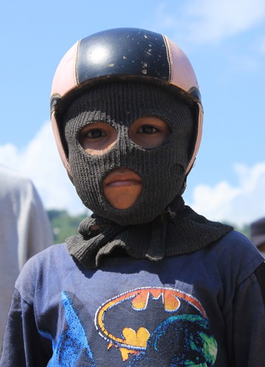 A kid with masker n helmet. It's needed to protect his face