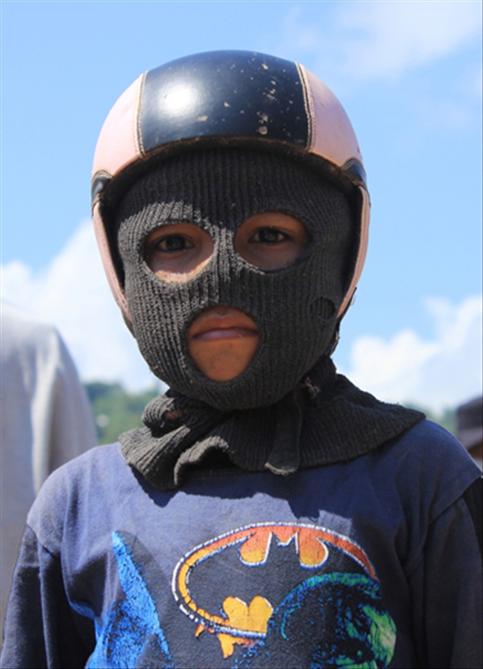 A kid with masker n helmet. It's needed to protect his face