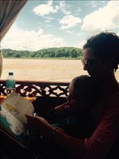 A boat tour on the mighty Mekong river. Reading a book to pass the time during our two-hour trip to the cave.: by hannap, Views[281]