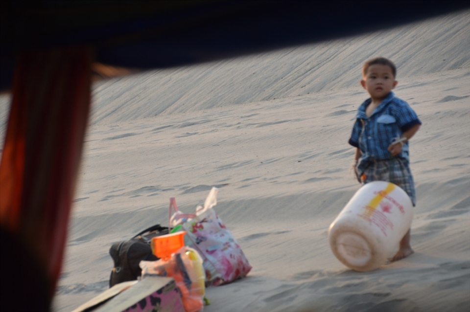 This boys face looks so innocent whilst his mother unloads the ferry trip after their rountined trip for supplies. I cant help but wonder what he's thinking.