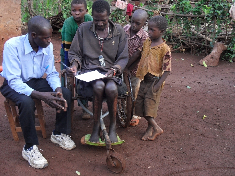 Visiting an old wheelchair who lives in an uphill area. He repaired the footpad by adding a piece of a plastic bucket material to comfort himself more. The callous along his legs caused by sitting on the ground for hours or crawling in order to do certain things which is easier without his wheelchair. Awareness of isolation prevention makes him always be near with his cellphone. In lack of luxury, a rosario hanging on his neck represents his religious character.