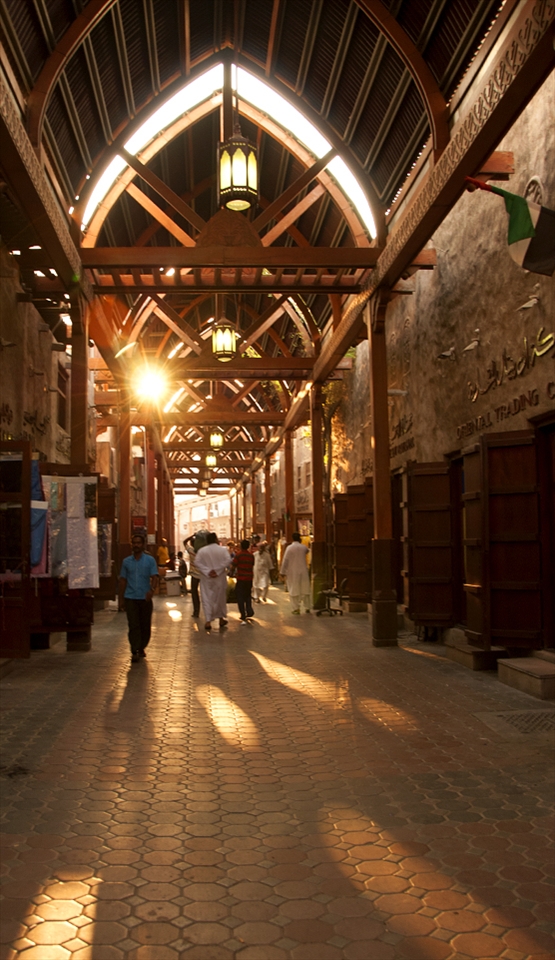 Wooden archways hold the smell of spice & sunlight in Bur Dubai Souq