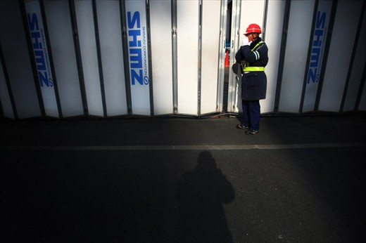 A worker blowing with cold hands, in one of the streets in the city of Tokyo.