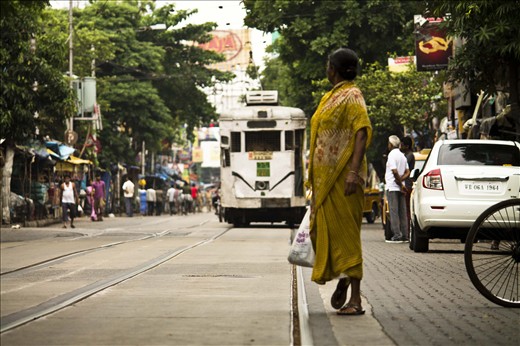THE TRAM - A WOMAN IS STANDING TO GET IN THAT TRAM . 
