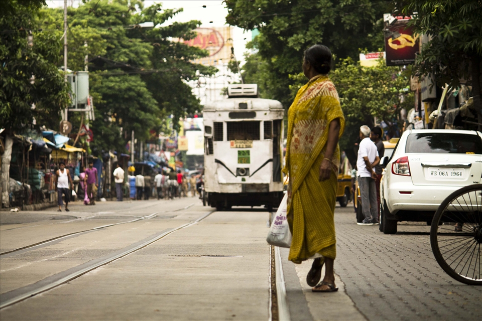 THE TRAM - A WOMAN IS STANDING TO GET IN THAT TRAM . 