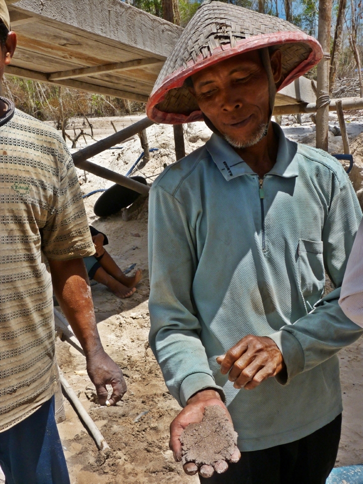A man clutches the sand containing his living. Gold is extracted from the sand. After many filtration processes, mercury - despite being illegal in Indonesia and damaging to the miners’ health, is used to extract the gold.