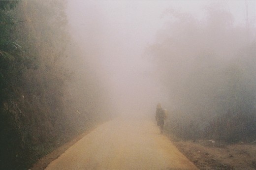 A woman looks back to see if the group are still behind her. It wouldn't be difficult to lose your companions in this thick fog.