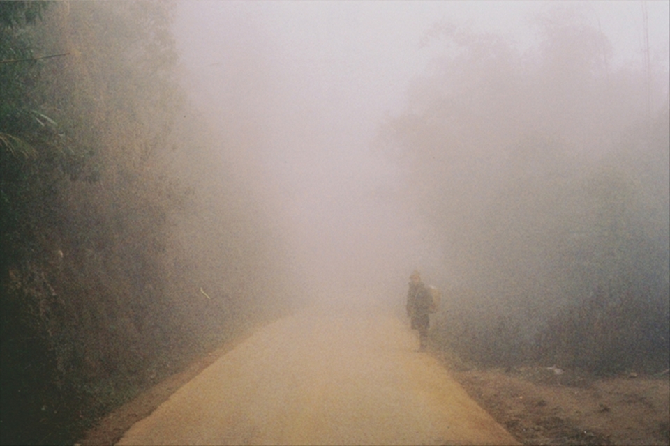 A woman looks back to see if the group are still behind her. It wouldn't be difficult to lose your companions in this thick fog.
