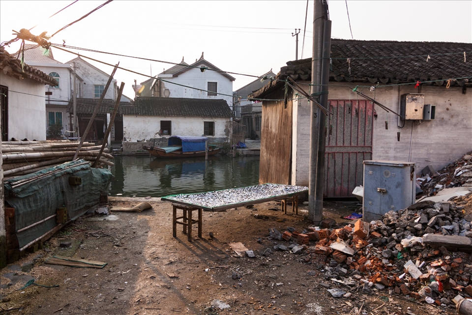 A villager leaves his catch of the day out in the setting sun to dry.
