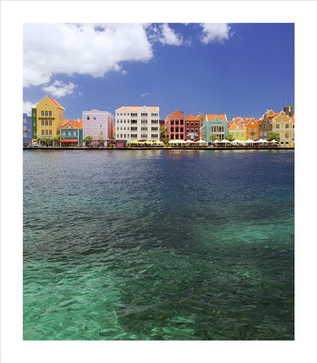 The colorful waterfront of Willemstad, Curacao’s capital city, showcases the classic pastel colors of the Dutch Caribbean. The two main tourist districts in Willemstad are Punda and Otrabanda, linked together by a floating pontoon bridge, which swings open to allow ships to enter the harbor.