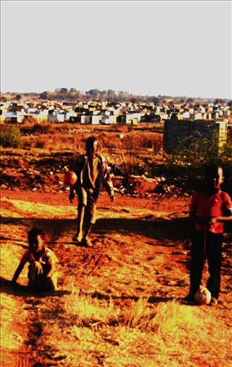 The boy who was waiting on the street is now playing soccer with his friends