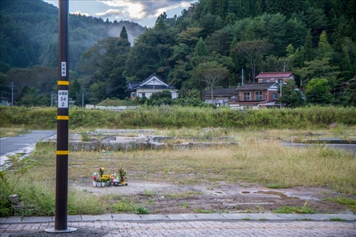 I couldn’t believe the tragedy: whole towns were wiped out by the tsunami, flattened to the ground. With this photo, I wanted to capture the haunting, eeriness that came from seeing hundreds of foundations of buildings, like skeletons. Flowers are left huddles together where homes once stood, and in the ironically peaceful, beautiful backdrop, those houses that were lucky enough to withstand the tsunami look on.