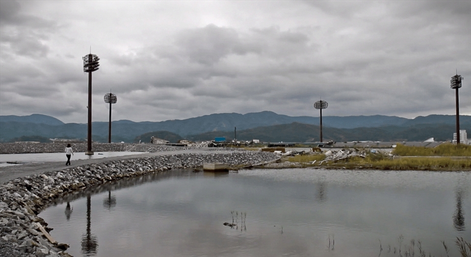 Opposite one of the only remaining buildings still standing in this area (a 6 story hotel where nothing remains except an empty shell from the 5th story down, showing just how high the wave was) was a space where a baseball pitch used to be. It was very quiet here, very calm. A flock of birds flew by just after I took this photo and together with the still floodwater and rolling hills almost made the scene seem peaceful. The harsh reminder of reality comes in the form of four floodlights, standing like lonely sentinels, the only notable thing that pierces the now desolate horizon.