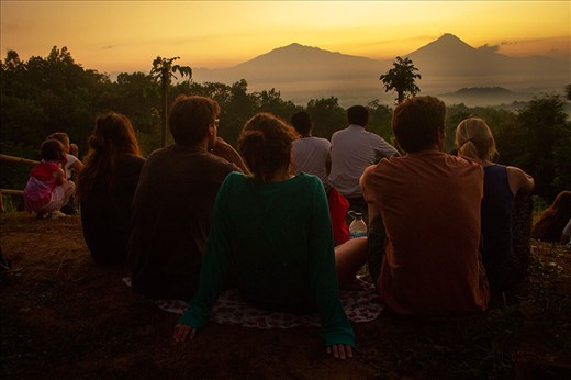 the tourists saw the sun rise in the hills surrounding the borobudur temple