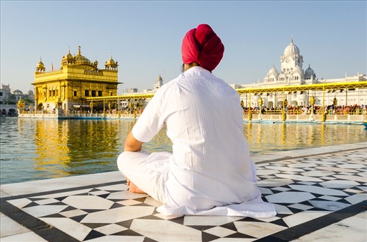 A holy man sits and prays at the Golden temple in Amritsar, India. This temple is an important place of worship for the Sikh faith. 

I set out early to make this image due to the hoards of tourist that usually crowd this temple. This allowed me to portray tranquility, peace and reflection through simple composition. I also made use of the golden hour, which washed over the site and enhanced the temples vivid golden colour.