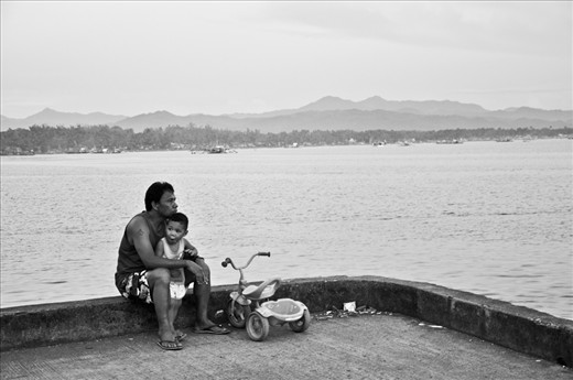 Grandfathers Love - i always bring my camera with me and  this day i decided to go the fishing port to watch the sunset. When i got there they got my attention because of how he protects and cared for his grandchild 
