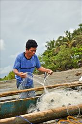 A fisherman fixing his nets getting ready to do what they do best. : by howardlim, Views[390]