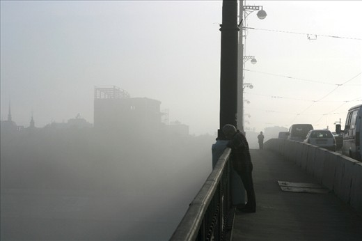 Man is staring into the river on a bridge in the Russian city of Irkutsk. Concei