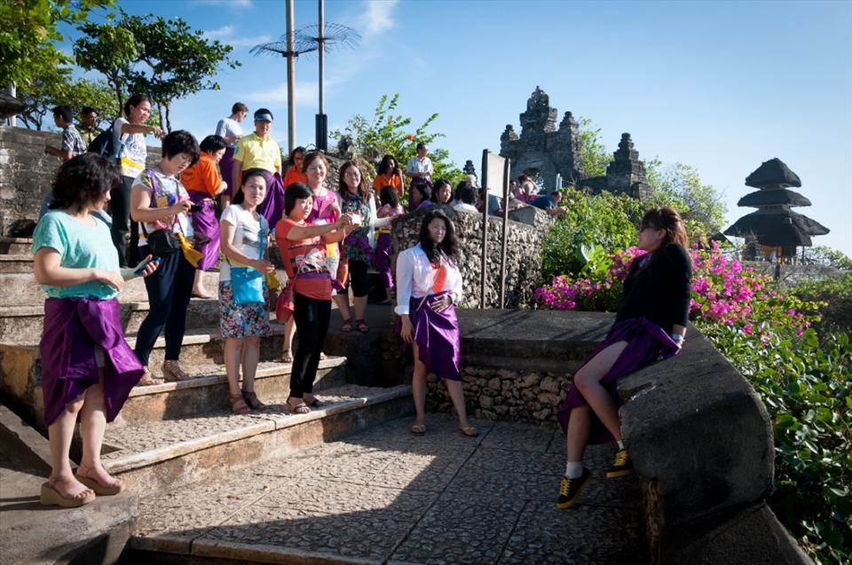 Tourists visiting the Uluwatu Temple, Bali, are required to wear a cloth around their waist to cover their private parts as a symbolic respect towards the Balinese deities. A proper cultural understanding could have avoided this unnecessary pose for a photograph, which could have angered the locals.