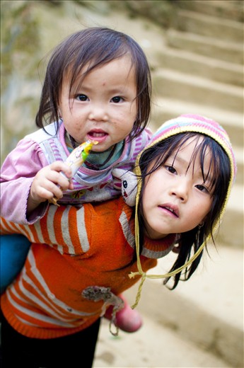The orange-shirt girl, after having her pictures taken, ran home and carried her baby sister to me, so she can have her pictures too.