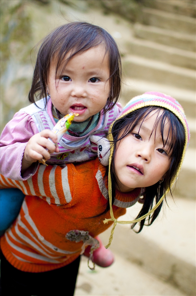 The orange-shirt girl, after having her pictures taken, ran home and carried her baby sister to me, so she can have her pictures too.