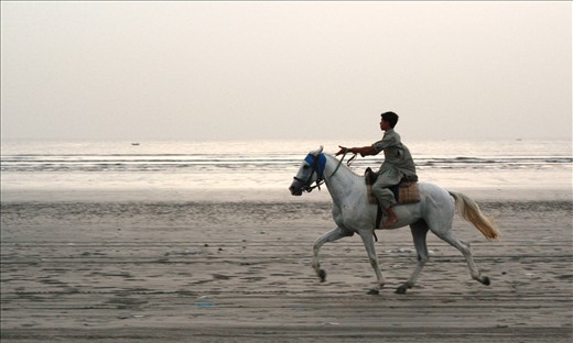 At dusk, a horse rider is seen galloping by the sea.
This moment is forever etched in my memory as it reminded me of the carefree days of my childhood. This young man  seemed to embody that freedom as he rode oblivious to the buzz of the city and its citizens. He seemed so free with each stride striking a musical note to one's ears. It was almost poetic...