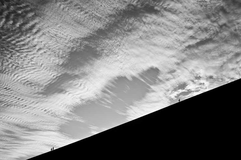 Climbing the largest dune, behind which is a hidden oasis.