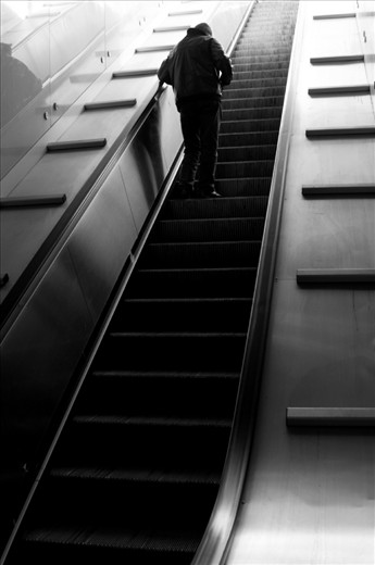 Naples City Metro escalator. Man checking his phone.  Almost everyone use touchphones, everywhere, everytime.