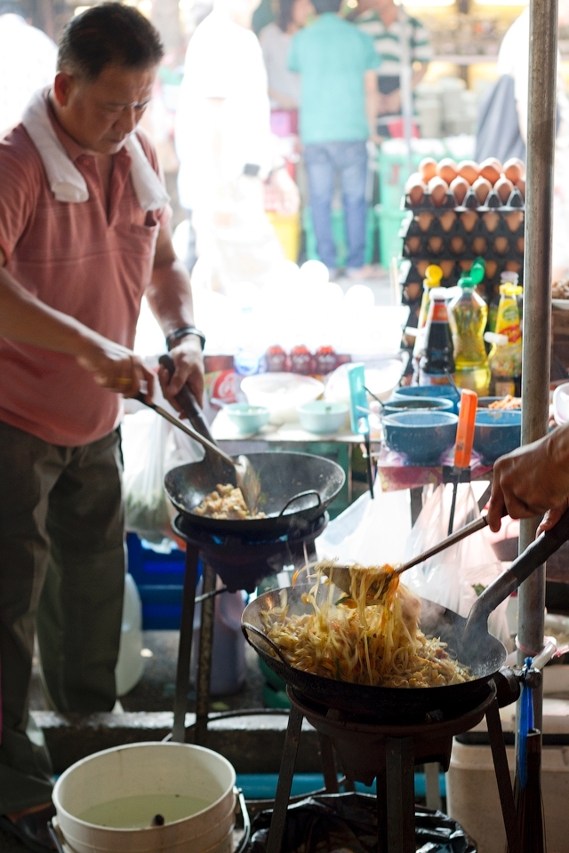 Chefs are cooking Pad Thai (possibly the most famous dish outside of Thailand) at the Chatuchak weekend market in Bangkok.